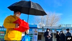 Family members collect the cremated remains of their loved one bundled with red cloth outside a crematorium in Beijing, Dec. 17, 2022.