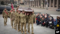 Ukrainian servicemen carry the coffin of their comrade Oleh Yurchenko, killed in a battle with Russian forces in the Donetsk, region during a memorial ceremony in Independence Square in Kyiv, Jan. 8, 2023. 