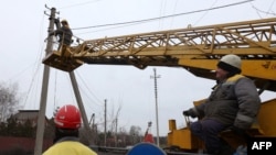 Workers repair broken power lines in Tatianovka village near Svyatohirs'k in Donetsk region on Nov. 25, amid the Russian invasion of Ukraine. 