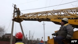 工人在顿涅茨克州斯维亚托戈尔斯克附近的一座村庄修复电线。(2022年11月25日)