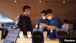 资料照：苹果北京商店内的员工和顾客（2022年9月16日）