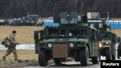 Soldados del Ejército de EEUU de la 82 División Aerotransportada desplegados en Polonia para apoyar a los aliados de la OTAN, se desplazan en un vehículo HMMWV (Humvee) en una base aérea, cerca de la localidad polaca de Arlamow, el 23 de febrero de 2022. 