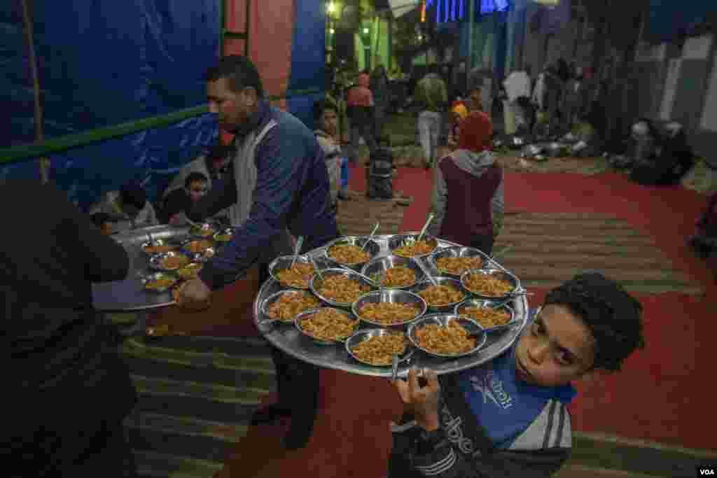Volunteers serve free meals to attendees of Hajj Zarief’s Christmas event in the village of Al-Sherif, Egypt. (Hamada Elrasam/VOA)