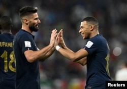 France's Kylian Mbappe celebrates scoring their second goal with Olivier Giroud at the World Cup Round of 16 match on December 4, 2022.