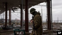 Un militar ucraniano patrulla cerca del puente Antonovsky, que fue destruido por las fuerzas rusas después de retirarse de Jersón, Ucrania, el 8 de diciembre de 2022.