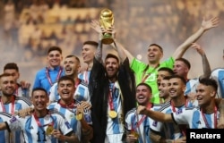 FILE - Argentina's Lionel Messi lifts the World Cup trophy alongside teammates as they celebrate winning the World Cup on December 18, 2022. (REUTERS/Carl Recine)