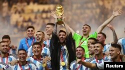 Lionel Messi dari Argentina mengangkat trofi Piala Dunia bersama rekan satu timnya saat mereka merayakan kemenangan melawan Prancis dalam Final Piala Dunia di Stadion Lusail, Lusail, Qatar, 18 Desember 2022. (REUTERS/Carl Recine)
