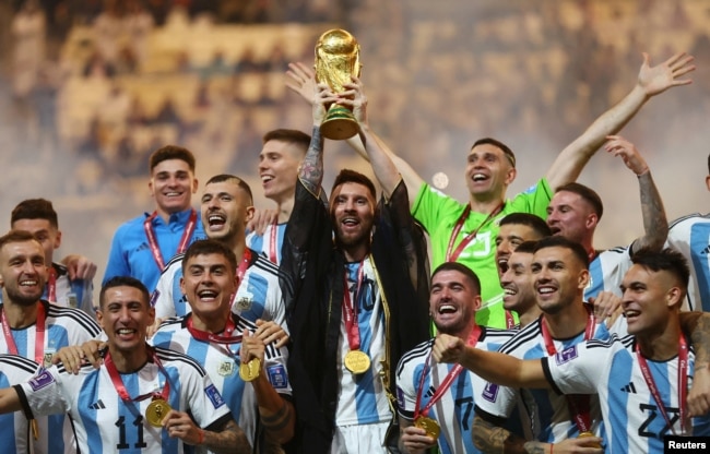 FILE - Argentina's Lionel Messi lifts the World Cup trophy alongside teammates as they celebrate winning the World Cup on December 18, 2022. (REUTERS/Carl Recine)