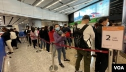 香港高铁西九龙总站售票大堂1月13日中午仍有大批旅客排队购票，车站指示牌显示等候时间约两小时 (美国之音/汤惠芸)