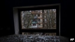 Broken glass lies on the floor of a building damaged during a Russian strike in Kherson, southern Ukraine, Nov. 25, 2022.