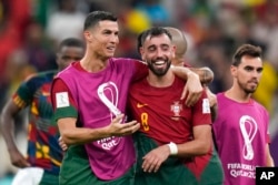 Portugal's Cristiano Ronaldo and Portugal's Bruno Fernandes celebrate their win during the World Cup group H soccer match between Portugal and Uruguay, at the Lusail Stadium in Lusail, Qatar, Nov. 29, 2022.