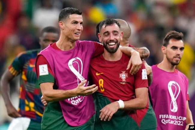 Portugal's Cristiano Ronaldo and Portugal's Bruno Fernandes celebrate their win during the World Cup group H soccer match between Portugal and Uruguay, at the Lusail Stadium in Lusail, Qatar, Nov. 29, 2022.