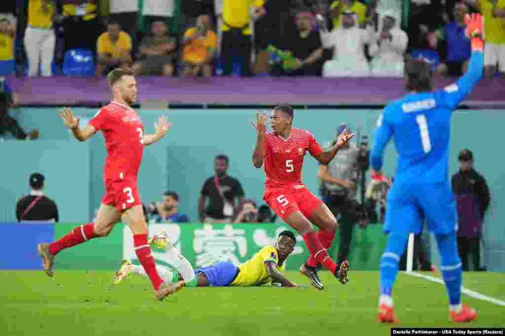 Jogador brasileiro, Vinicius Jr, derrubado pelo defesa suíço, Manuel Akanji, em jogo do grupo G do Mundial do Qatar, no Stadium 974, em Doha. Nov 28, 2022