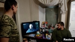 Ukrainian soldiers watch Ukraine's President Volodymyr Zelenskiy’s New Years Eve address to the nation, in a military rest house, as Russia's attack on Ukraine continues, in region of Donetsk, Dec. 31, 2022. 