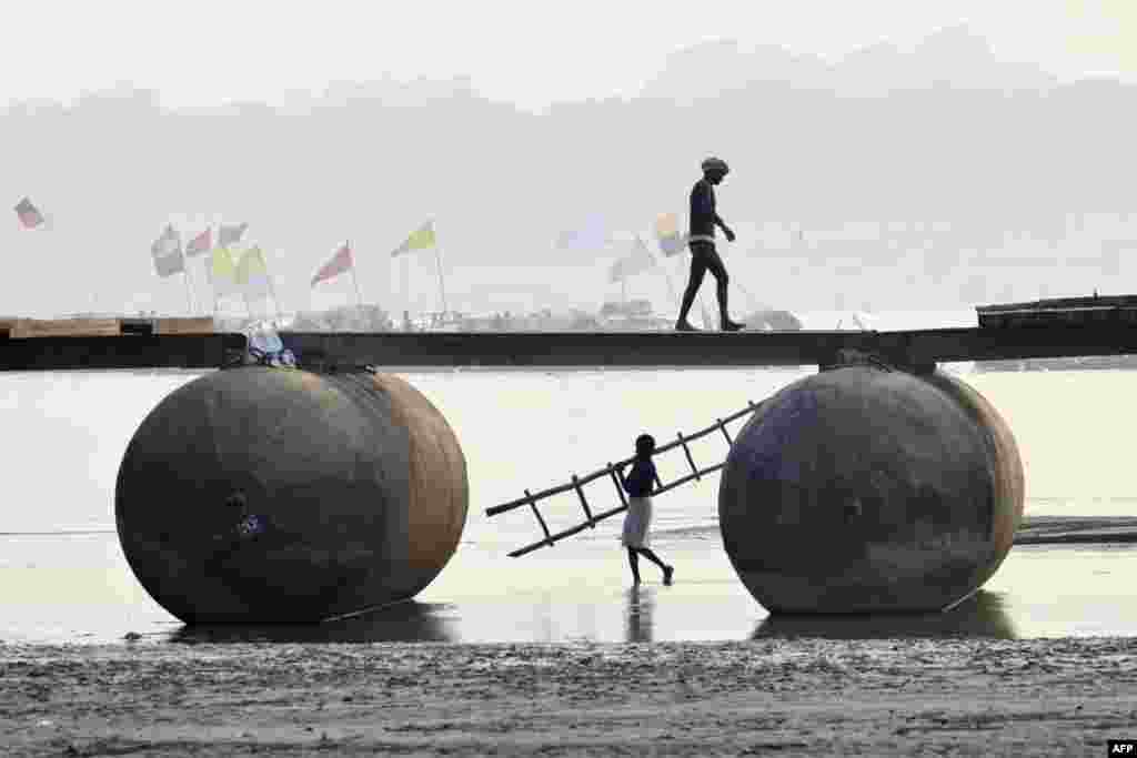Laborers build a floating pontoon bridge on the Ganges River during preparations for the upcoming annual Hindu religious fair of Magh Mela in Prayagraj, India.