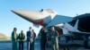 英国首相里希·苏纳克（前排左起第二）2022年11月9日访问英国皇家空军基地康宁斯比时同有关人员交谈。英国刚刚宣布将同意大利和日本联合研制下一代战机。