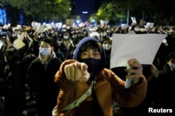 北京民眾走上街頭舉起白紙遊行抗議當局嚴厲的防疫封控措施。（2022年11月27日）