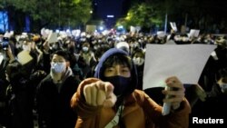 2022年11月27日，北京民眾走上街頭舉起白紙遊行抗議當局嚴厲的防疫封控措施。（路透社照片）