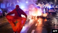 Navijač sa zastavom Maroka ispred mesta gde su se demonstranti sukobili sa policijom u Briselu