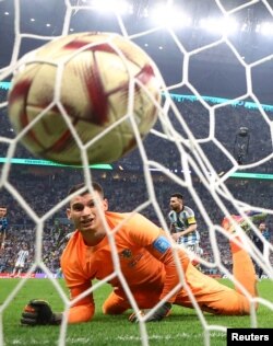 Argentina's Lionel Messi, right, celebrates while Croatia's Dominik Livakovic reacts to a goal in the FIFA World Cup Qatar 2022 semifinal against Croatia in Lusail, Qatar, Dec. 13, 2022.