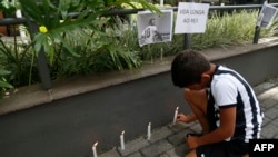 A child fan of Santos lights a candle next to a picture of Brazilian football legend Pele during a vigil outside the Albert Einstein Israelite Hospital entrance, where the former player is hospitalized in Sao Paulo, Brazil, on Dec. 4, 2022.