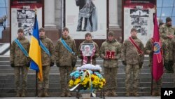 Ukrainian servicemen stand guard at the coffin of their comrade Oleh Yurchenko, killed in a battle with Russian forces in Ukraine's Donetsk region, during a memorial ceremony in Independence Square, in Kyiv, Ukraine, Jan. 8, 2023.