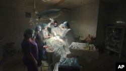 This photo made available by Ukrainian doctor Oleh Duda shows the moment when lights at a hospital went out as he was performing complicated, dangerous surgery. (Oleh Duda via AP)