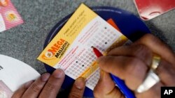 Un jugador llena un boleto para la lotería Mega Millions.