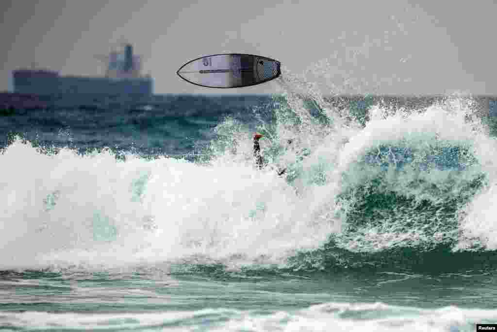 A surfboard flies over the head of a surfer on the Mediterranean sea shore of Ashkelon, Israel.