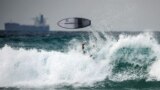 A surfboard flies over the head of a surfer on the Mediterranean sea shore of Ashkelon, Israel, Jan. 12, 2023.