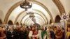 Sejumlah warga menyanyikan lagu-lagu Natal di dalam stasiun metro di Kyiv, pada 25 Desember 2022. (Foto: Reuters/Valentyn Ogirenko)