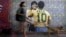 A woman walks her dogs by a wall with an image depicting late football stars Diego Maradona of Argentina and Pele of Brazil embracing each other, in Buenos Aires on Dec. 29, 2022, just hours after the passing of Pele.