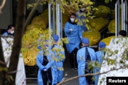 上海一家火葬場的工作人員走過數個逝者的屍袋。（2023年1月4日）