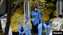 上海一家火葬场的工作人员走过数个逝者的尸袋。（2023年1月4日）
