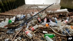 FILE - Bottles and other plastics, including a mop, lie washed up on the north bank of the River Thames in London, Feb. 5, 2018. England will ban a range of single-use plastic items starting in October 2023 to limit pollution, officials said Jan. 14, 2023.