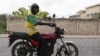 Un chauffeur de taxi moto sur sa moto électrique pose pour une photo dans les rues de Cotonou, le 21 octobre 2022.