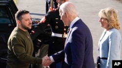 El presidente Joe Biden (der.) le estrecha la mano al presidente ucraniano, Volodymyr Zelenskyy, al darle la bienvenida junto a la primera dama de EEUU, Jill Biden, en la Casa Blanca, el 21 de diciembre de 2022, en Washington.