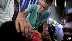 FILE - A Norwegian doctor treats a Palestinian girl in a hospital in Gaza City, where the power goes off repeatedly as aging hospital generators buckle under daily rolling blackouts Gaza residents have lived with for years. 