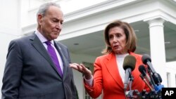 FILE - Senate Majority Leader Chuck Schumer of N.Y., right, listens as House Speaker Nancy Pelosi of California speaks to reporters at the White House in Washington, Nov. 29, 2022.