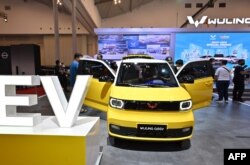 Pengunjung mengamati mobil listrik produksi mobil China Wuling saat pameran mobil di Tangerang, 15 November 2021. (ADEK BERRY/AFP)