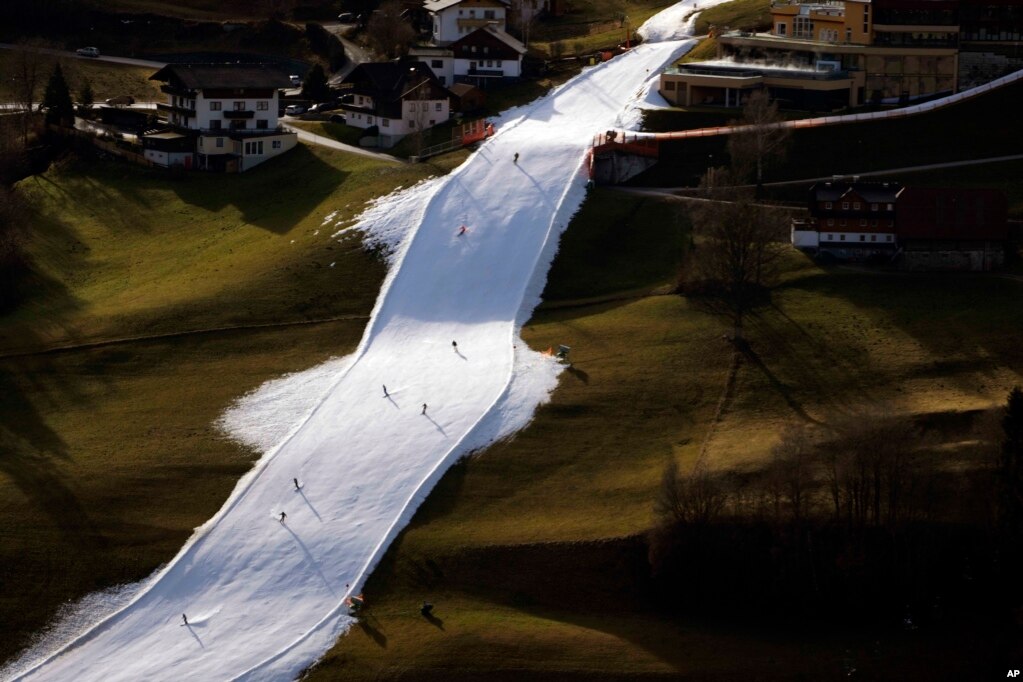 People skiing on a slope near Schladming, Austria. Sparse snowfall and unseasonably warm weather in much of Europe is allowing green grass to blanket many mountaintops across the region where snow might normally be.