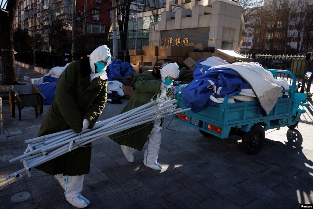 身穿防护服的大白拆除北京一个居民区的封控和检测装置。（2022年12月10日）(photo:VOA)