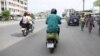 Eraste Padonou, boulanger, roule avec sa moto électrique de chez M Auto sur les routes de Cotonou le 21 octobre 2022.