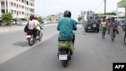 Eraste Padonou, boulanger, roule avec sa moto électrique de chez M Auto sur les routes de Cotonou le 21 octobre 2022.