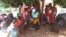 Zanu PF official writing names of people registering to vote in Mashonaland West at the ZEC offices