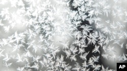 Frost forms on a storm window during a blizzard warning, Dec. 23, 2022, in Iowa City, Iowa.