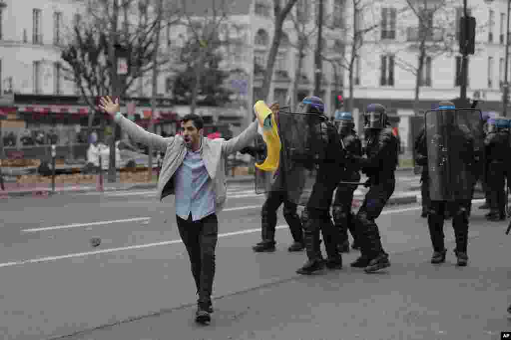 A member of the Kurdish community tries to calm demonstrator during clashes with police officers during a protest against the recent shooting at the Kurdish culture center in Paris, France, Dec. 24, 2022.