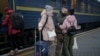 Ukrainian soldier Vasyl Khomko, 42, meets his daughter Yana and his wife Galyna, left, at the train station in Kyiv, Dec. 31, 2022. 