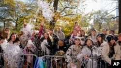 Spectators toss confetti as the Macy's Thanksgiving Day Parade makes its way down Central Park Avenue West, Nov. 24, 2022, in New York.