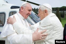 FILE - Pope Francis (L) embraces Pope Emeritus Benedict XVI as he arrives at the Castel Gandolfo summer residence, Italy, March 23, 2013.